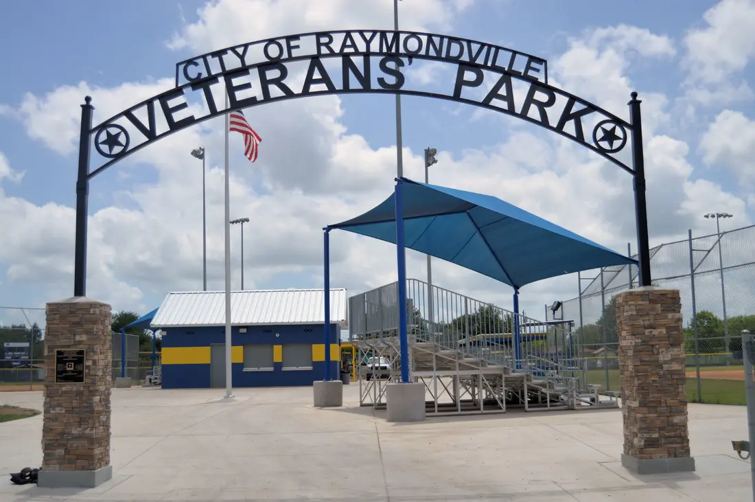 A sign that says veterans park in the city of raymond.